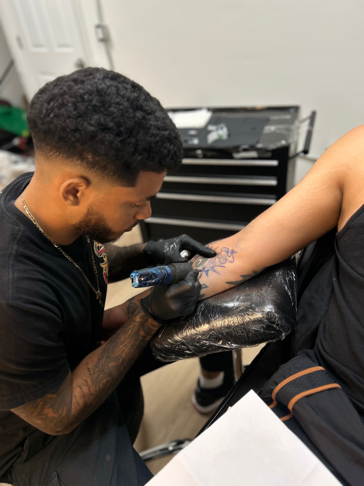 Vito tattooing a client's arm in the studio