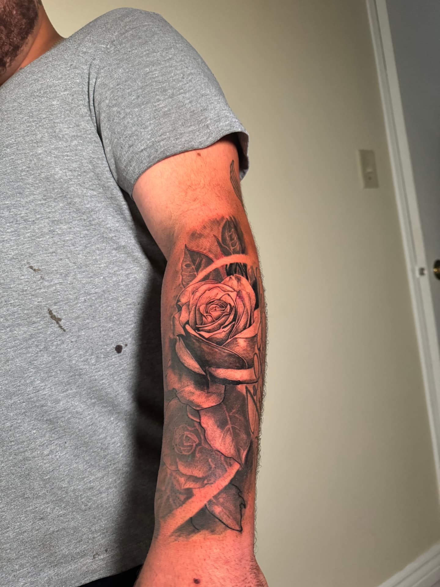 Black-and-grey realism rose tattoo on a forearm